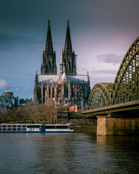 Nice black and white picture of the great Dom of Koln in Germany. In this picture you see the industrial railway bridge near this big cathedral at the banks of river Rhine.