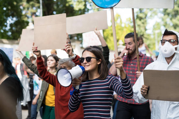 istock People with placards and amplifier on global strike for climate change. 1195621755