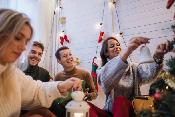 istock Lovely friends decorating a Christmas tree together and having fun 1195622717