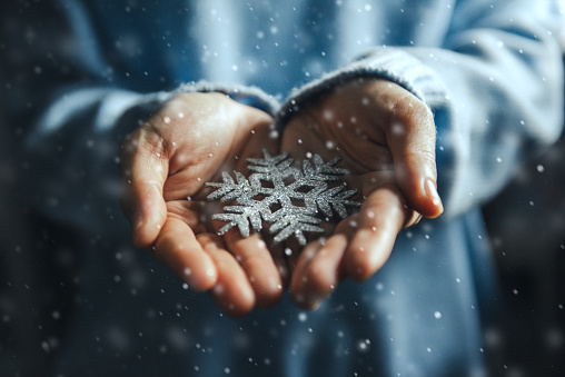 Close up woman hands holding snowflake, Christmas decorative ornament concept