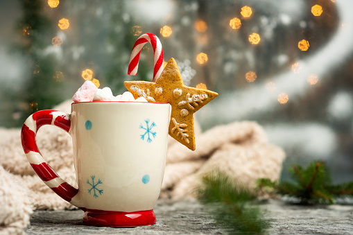 Warm marshmallow dessert beverage on Christmas decorated table with festive background