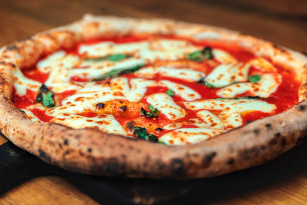 istock Freshly baked pizza on a wooden table 1195628243