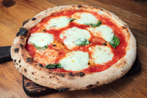 istock Freshly baked pizza on a wooden table 1195628273