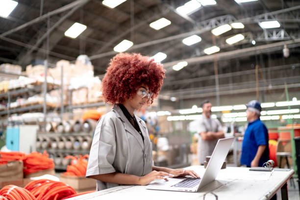 istock Employee using laptop and working in a factory 1195629524