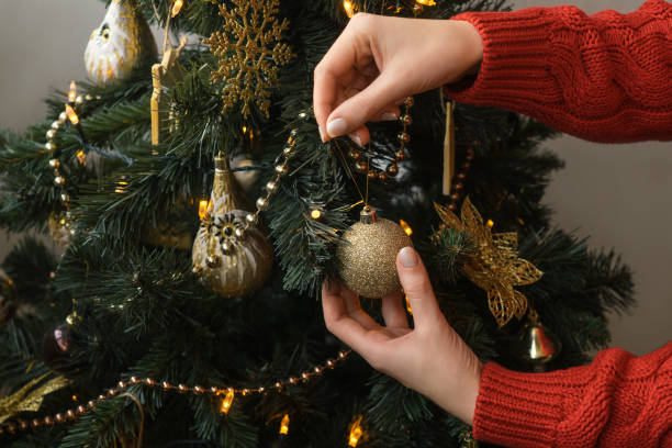 istock Womans hand hang christmas ball. 1195630121