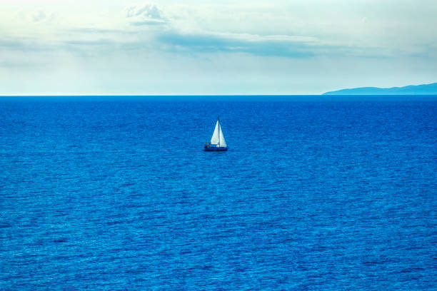 istock lonely boat at sea (HDRi) 1195630175