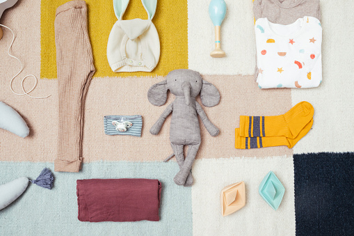 From above photo of composition with clothes toys and accessory for a newborn baby.