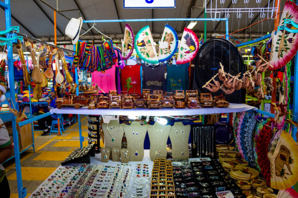 lembranças étnicas, bonés de beisebol, bolsas com vários padrões pendurados no mercado de rua - baseball cap hat merchandise nature - fotografias e filmes do acervo