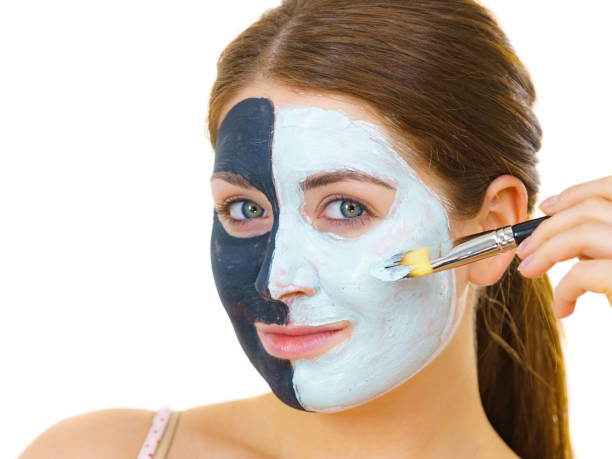 istock Girl black mask on half face apply white mud 1195640010