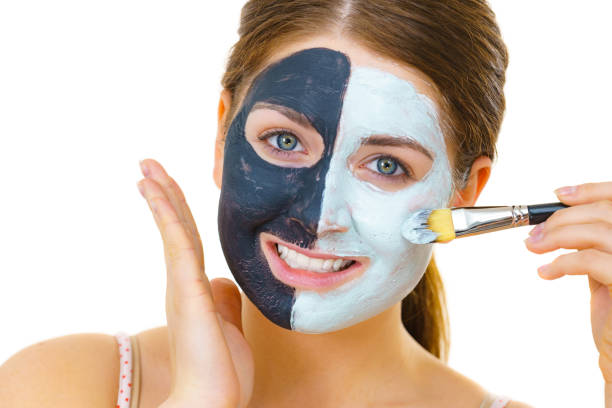 istock Girl black mask on half face apply white mud 1195640020