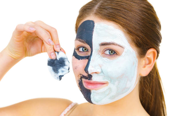 istock Girl remove black white mud mask from face 1195643142