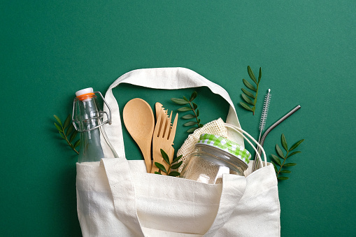 Bolsa de lona reutilizable con cubiertos de bambú ecológicos, pajitas para beber metal, frasco de vidrio y botella. Cero residuos, concepto libre de plástico. Estilo de vida sostenible photo