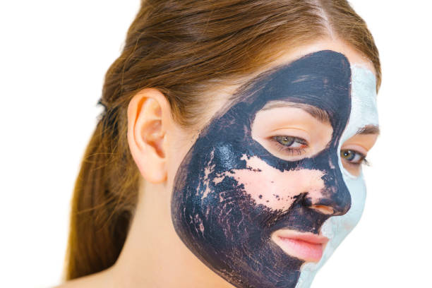 istock Girl remove black white mud mask from face 1195644106