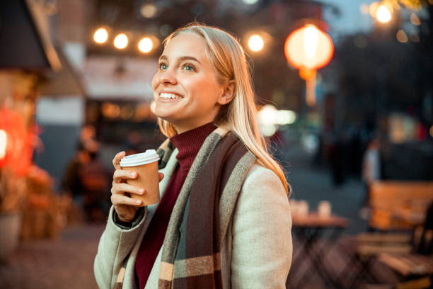 istock Happy pretty female ejoying hot drink outdoors 1195647191