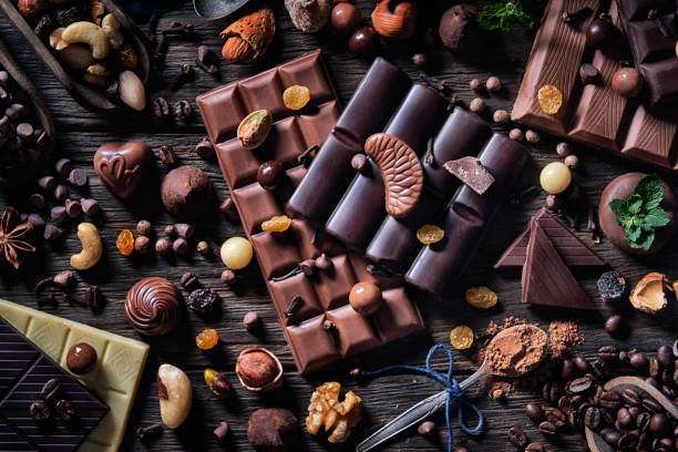 ココアパウダーとドライフルーツを昔ながらのスタイルでチョコレートとボンボンのローキーバラエティ - chocolate chocolate candy dark chocolate directly above ストックフォトと画像