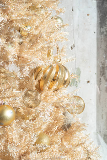 istock Glittery gold Christmas ornaments on a gold artificial tree - vertical 1195658510
