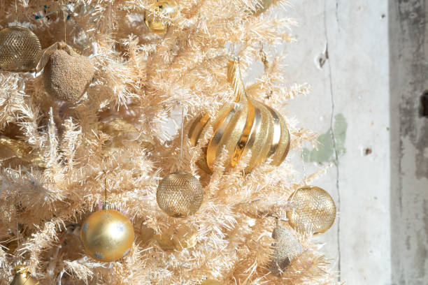 istock Glittery gold Christmas ornaments on a gold artificial tree 1195658511