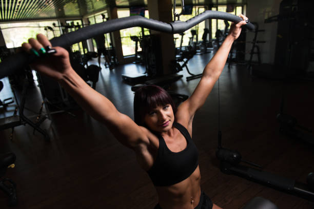 istock Beautiful Woman Exercising Back On Machine 1195663784