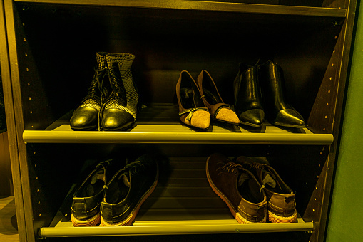 Men's and women's shoes on a shoe rack
