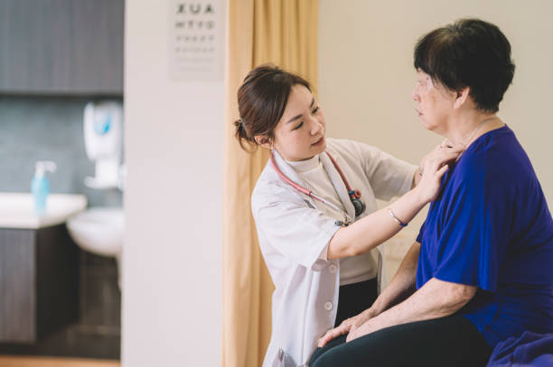 an asian chinese female doctor examining an asian chinese senior woman at clinic consultation room an asian chinese female doctor examining an asian chinese senior woman at clinic consultation room consultation with doctor stock pictures, royalty-free photos & images