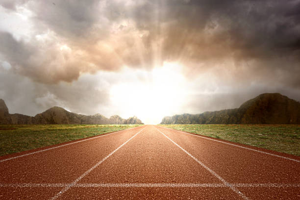 Running track with green grass and mountain view Running track with green grass and mountain view with sunlight background sports track stock pictures, royalty-free photos & images