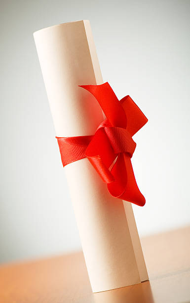 istock Education concept - diploma roll on the wooden table 119569042