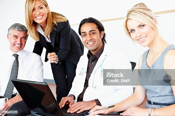Happy Multiracial Business Team Working On Laptop With Doctor Stock Photo - Download Image Now