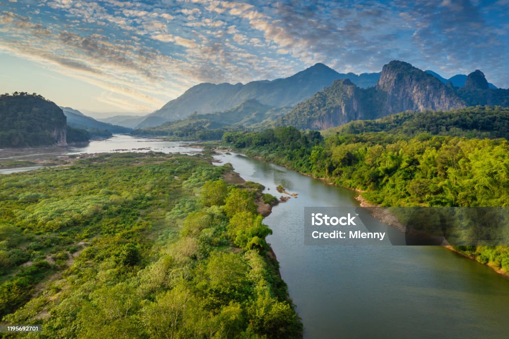 Mekong River in Laos Luang Prabang Pak Ou Drone View Aerial Drone Point of view of the beautiful Mekong River under beautiful twilight skyscape floating between the rolling landscape between the city Luang Prabang and Pak Ou, Mekong River, Luang Prabang, Laos, Southeast Asia Mekong River Stock Photo