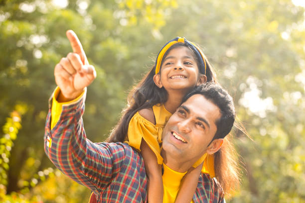 ピギーバックライドを楽しむ父と娘 - offspring family love india ストックフォトと画像