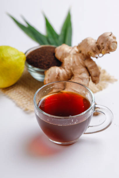 istock Black tea with ginger and lemon over white background 1195699664