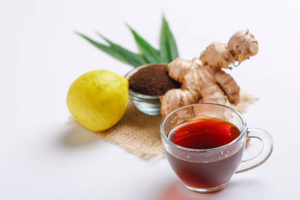istock Black tea with ginger and lemon over white background 1195699734