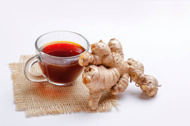 Black tea with ginger and lemon over white background