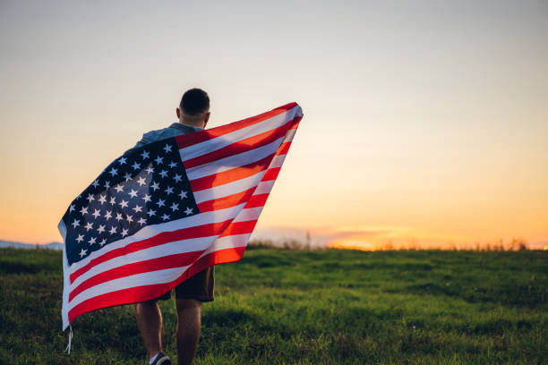 istock Man with American flag on meadow 1195706125