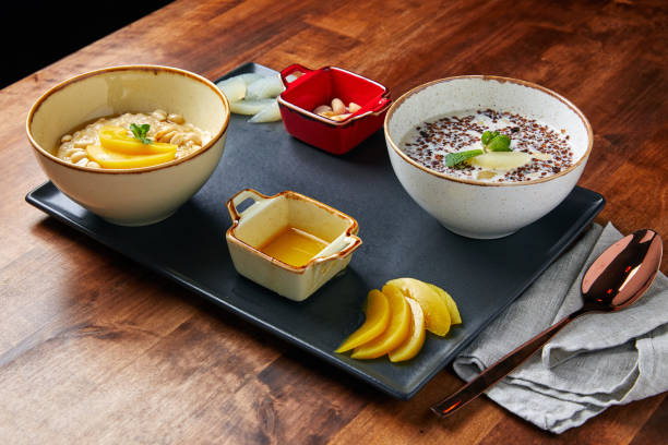 proper food tray, oatmeal and buckwheat porridge with milk, nuts and beans, mango and sauce, on a wooden table