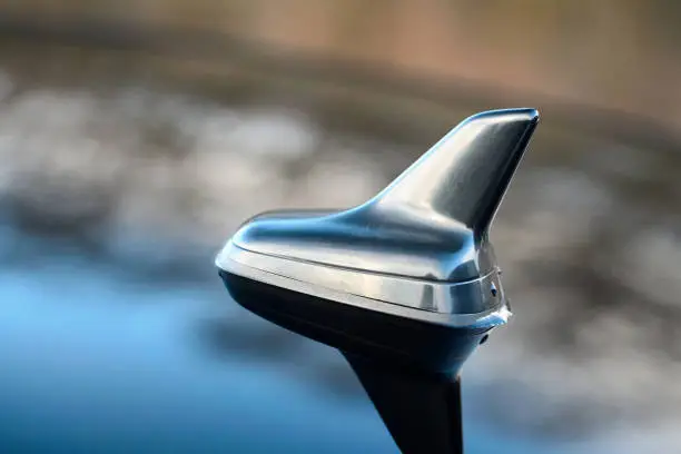 Photo of GPS antenna shark fin shape on a roof of german car for radio navigation system.