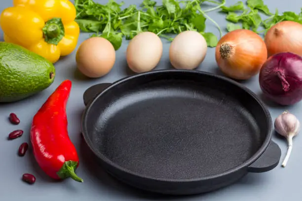 Photo of Frying pan. A set of vegetables for healthy diet, eggs, peppers,