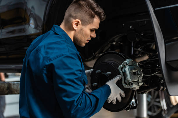 istock young, attentive mechanic installing disc brakes on raised car 1195719251