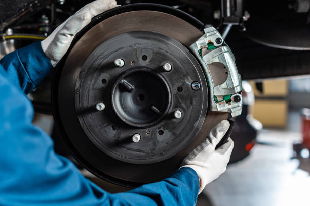 przycięty widok mechanika regulacji zmontowanych hamulców tarczowych z zacisku hamulcowego - brake car repairing auto repair shop zdjęcia i obrazy z banku zdjęć