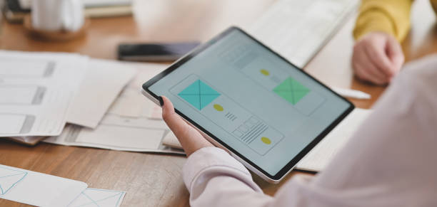 istock Close-up view of young  ui web designer working on her concept with tablet 1195719511