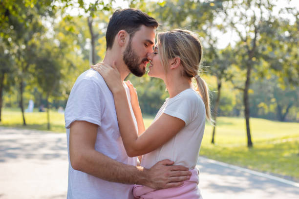 istock Couples standing kiss and hugging in the park. 1195719584