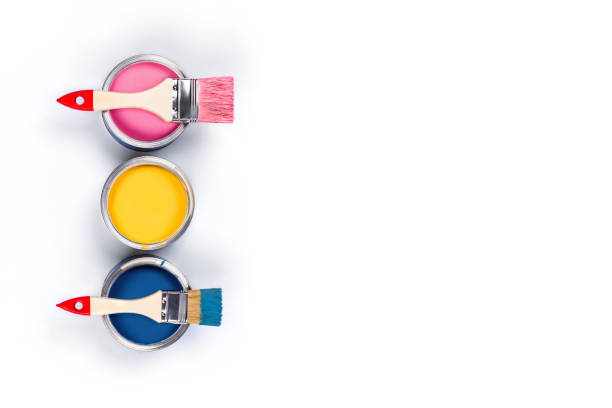 istock White background with three colored paint jars and brushes. 1195723489