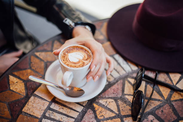 Lady's hands holding cup with sth heart-shaped
