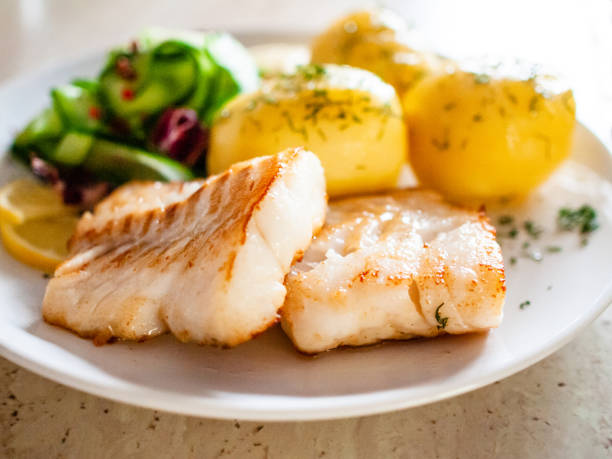 istock Fried cod fillet with boiled potatoes and vegetables 1195727039