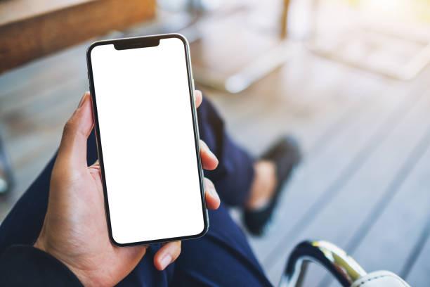 un uomo che tiene il cellulare nero con schermo bianco vuoto - telephone mobile phone human hand smart phone foto e immagini stock