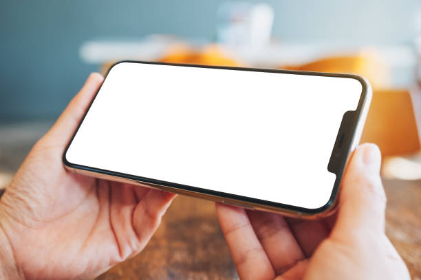 istock hands holding black mobile phone with blank desktop screen 1195729386