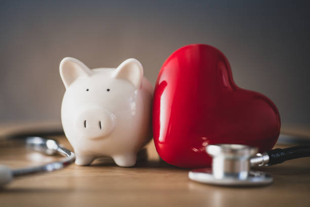 salvadanaio con cuore rosso - currency stethoscope healthcare and medicine savings foto e immagini stock