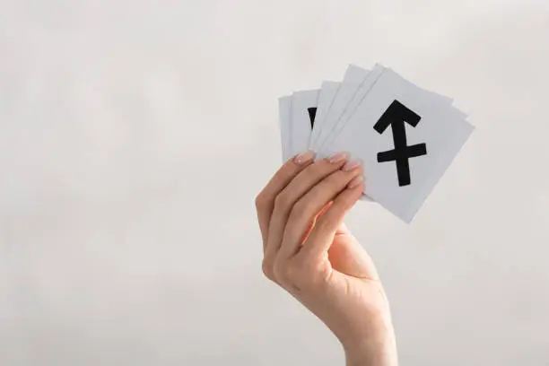 Photo of Cropped view of woman holding cards with zodiac signs isolated on grey