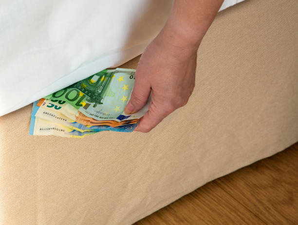 istock Putting money under the bed mattrac 1195734646