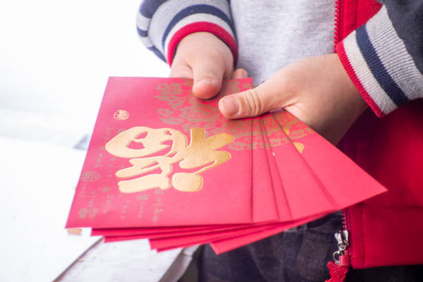 子供たちは伝統的な中国の赤い封筒を手に持っている - hong bao ストックフォトと画像