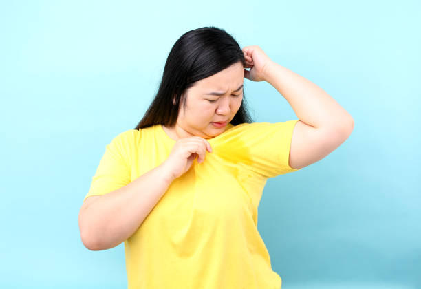 肖像画アジアの女性過度に悪いに汗をかき、スタジオで青い背景に隔離。 - sweat armpit sweat stain shirt ストックフォトと画像